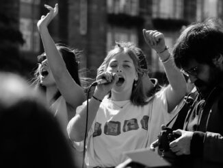 Protesters speaking passionately into a microphone.