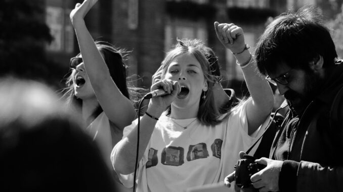 Protesters speaking passionately into a microphone.