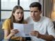 Couple looking shocked at a bill.