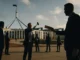 Men discussing outside a government building.