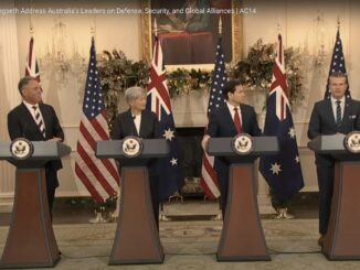 Four officials at podiums with flags behind.