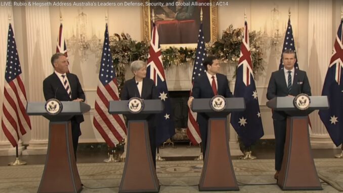 Four officials at podiums with flags behind.