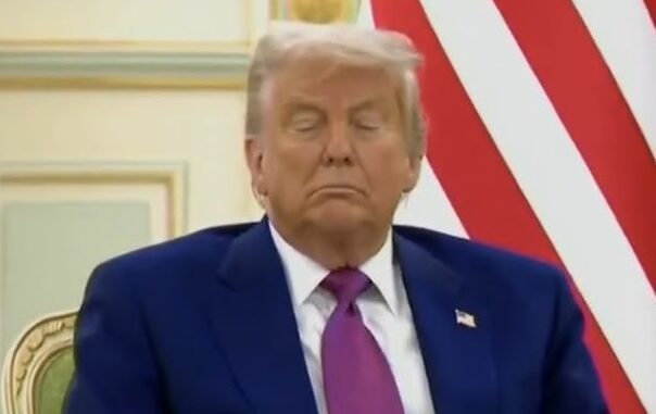 Man in suit with closed eyes indoors.