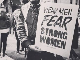 Person holding sign about strong women.