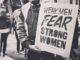 Person holding sign about strong women.