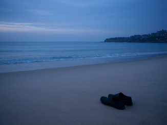 Shoes on sandy beach at dusk.