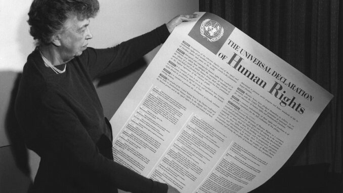 Person holding Universal Declaration of Human Rights.