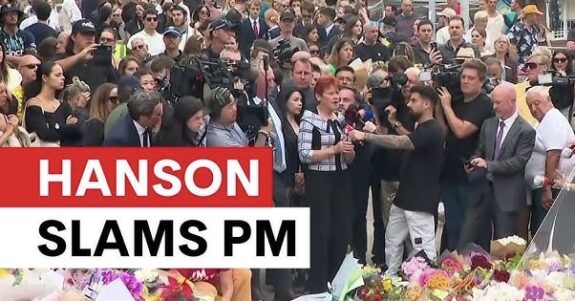 Crowd gathered with media, floral tributes visible. Crowd gathered with media, floral tributes visible.