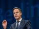 Man in suit speaking at Berlin event.