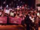 Crowd holding peace and security banners.