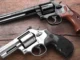 Two revolvers on a wooden surface.