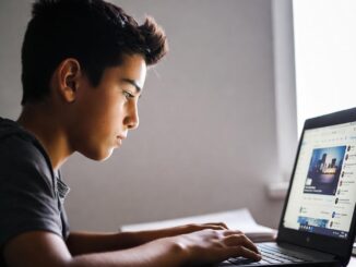 Boy using a laptop at home desk.