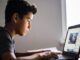Boy using a laptop at home desk.