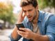 Man looking at phone with concern outside.