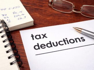 Notebook, pen, and "tax deductions" document.