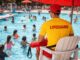 Lifeguard watching over busy swimming pool.