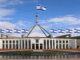 Parliament House with multiple Israeli flags flying.