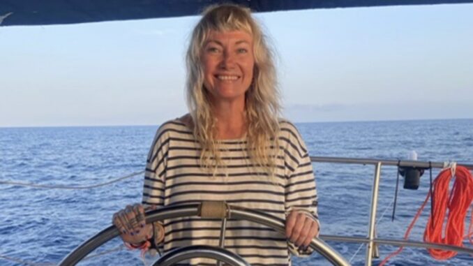 Smiling woman steering sailboat on ocean. Smiling woman steering sailboat on ocean.