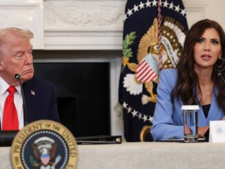 Two people speaking at a conference table.
