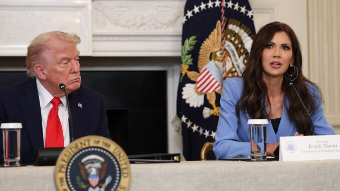 Two people speaking at a conference table.