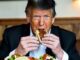 Man eating tacos at a restaurant table.