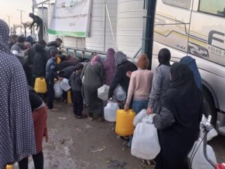 People collecting water from large containers.