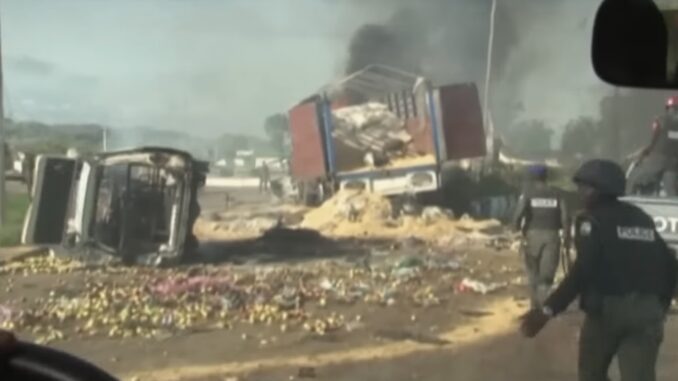 Overturned truck with debris and smoke.