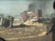 Overturned truck with debris and smoke.