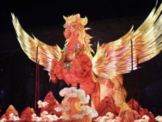 Illuminated phoenix sculpture with vibrant wings.