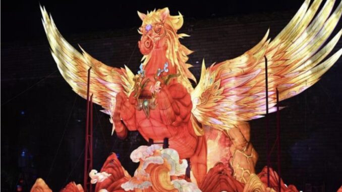 Illuminated phoenix sculpture with vibrant wings.