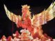 Illuminated phoenix sculpture with vibrant wings.