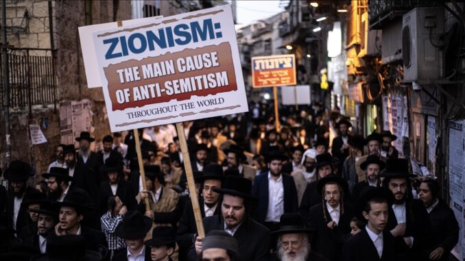 Protesters with signs on crowded street.