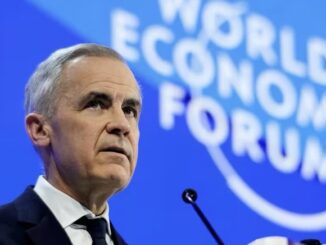 Gray-haired man addressing World Economic Forum stage