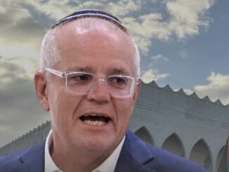 Man speaking with building and sky background.