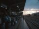 Crowded train platform at sunset.