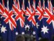 Australian flags surrounding hidden person at podium.