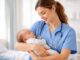 Nurse holding a sleeping baby lovingly.