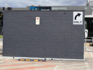 Brick wall with right turn sign.