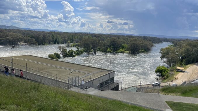 River flooding near a building and trees.