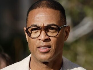 Man wearing glasses outdoors, looking forward.