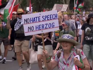 Protesters marching with signs and flags.