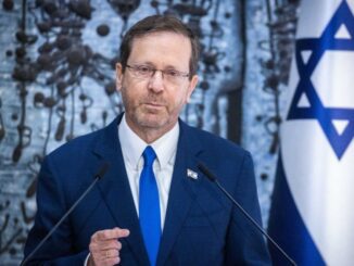 Man speaking at podium with Israeli flag.