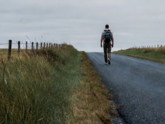 Man walking alone on a rural road.