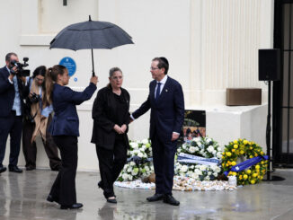 People paying respects at a memorial ceremony.
