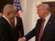 Two men shaking hands in formal setting.