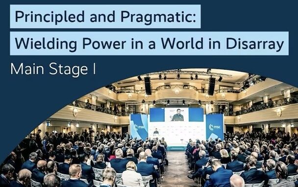 Conference audience in a large auditorium setting.