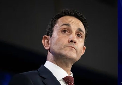 Man in suit looking upwards, serious expression.