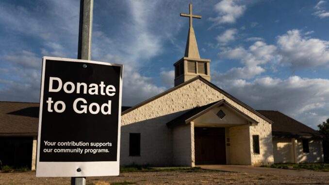 Church with donation sign in foreground.