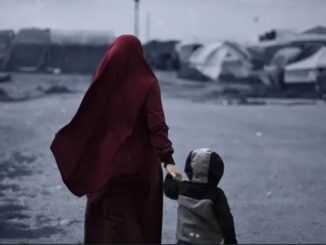 Woman and child walking through refugee camp.