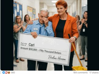 Man receives large check, surrounded by people.